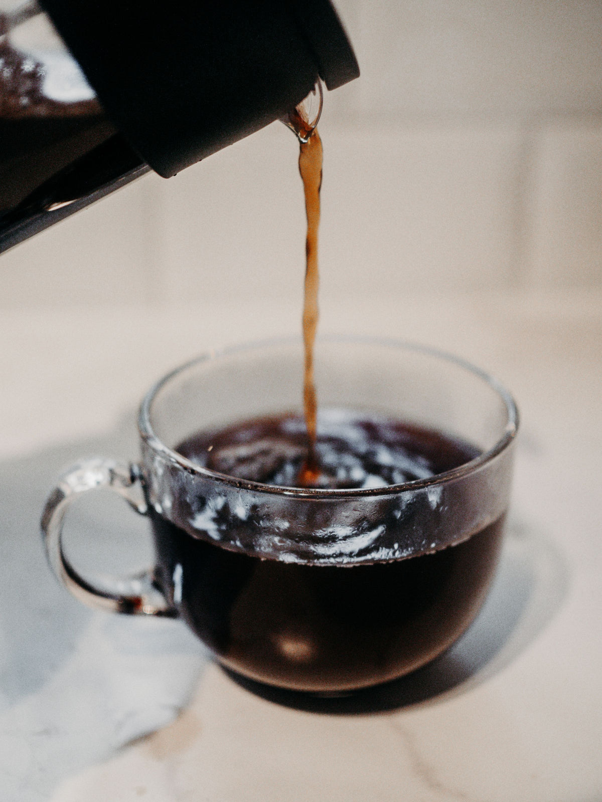 Filter coffee pouring into a glass cup