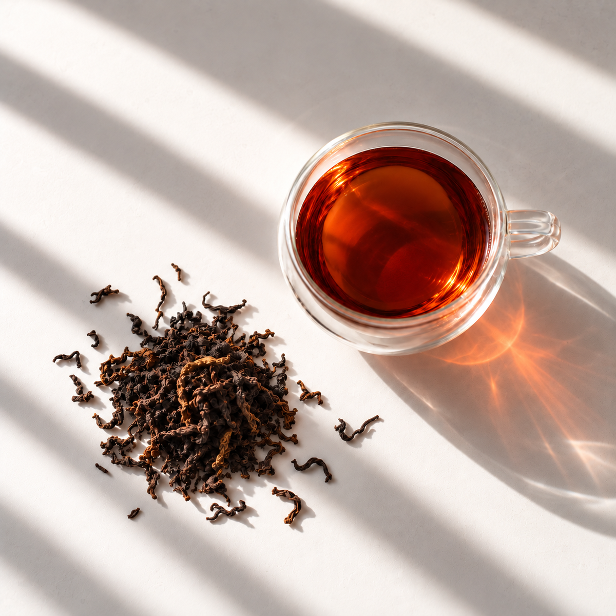 Assam Black Tea: loose leaf and a glass cup of brewed tea
