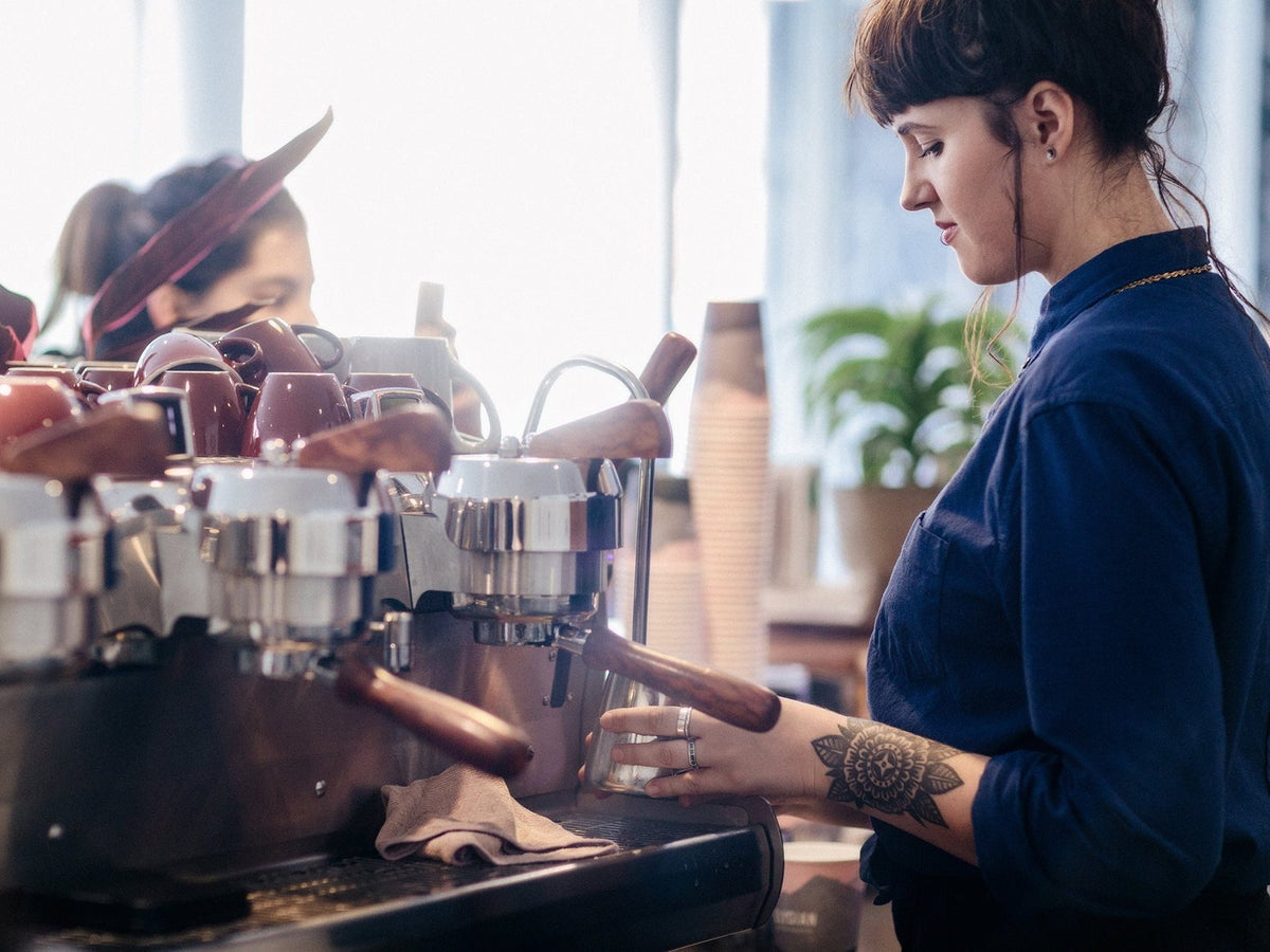 A barista pulling espresso shots in an Elysian cafe